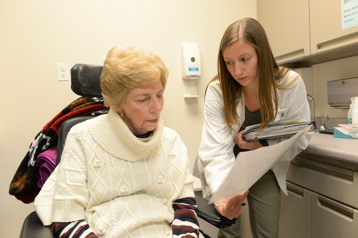 A woman reviews a document with a health care professional.