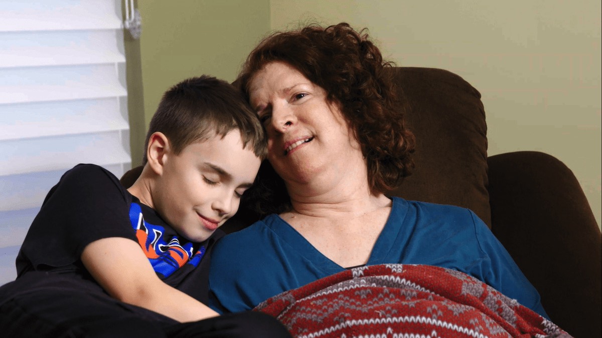 A woman sits in a recliner with a young child.