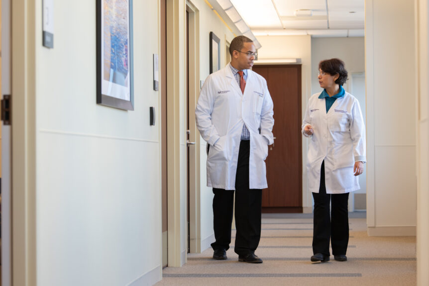 Drs. Jonathan Brent and Senda Ajroud-Driss converse in a hallway.